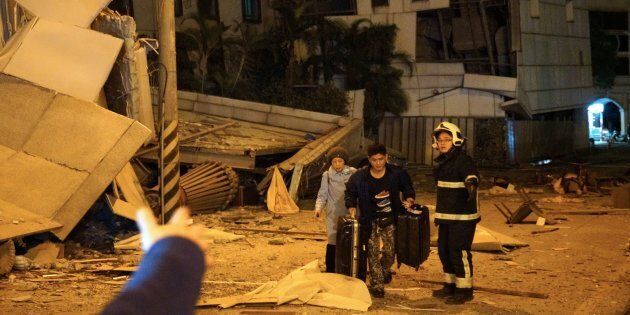 Two guests are escorted by rescue workers from the damaged Marshal Hotel in Hualien, eastern Taiwan early on Feb. 7, 2018, after a strong earthquake struck the island.