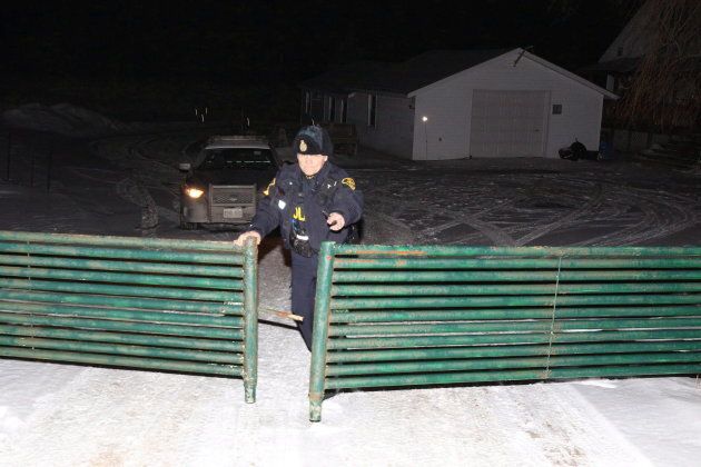 OPP officer closes the gate at the driveway at a property north of Madoc, Ont., on Jan. 18, 2018.