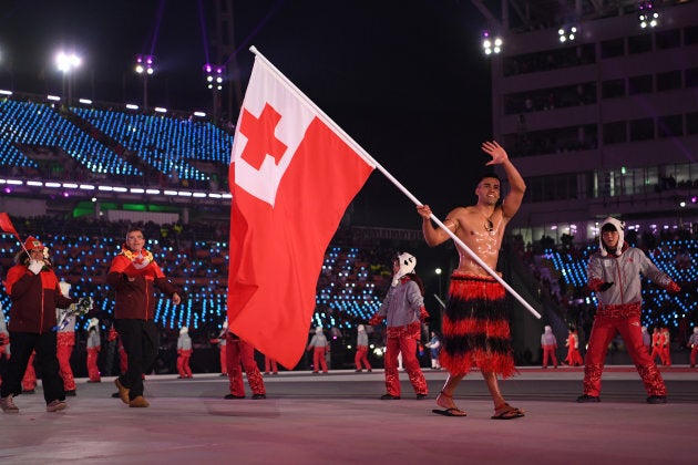 Flag bearer Pita Taufatofua of Tonga leads his country out during the opening ceremony.