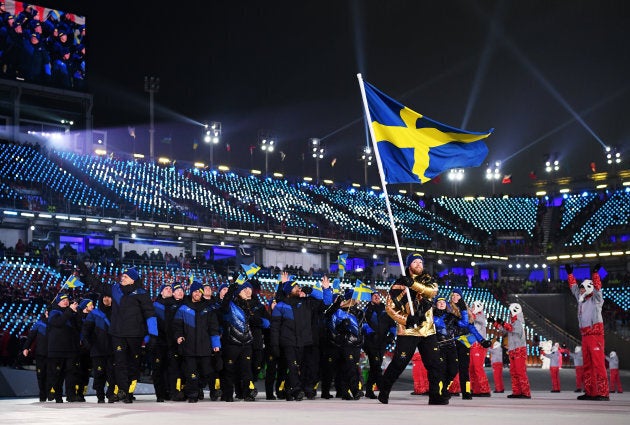 Flag-bearer of Sweden Niklas Edin and teammates enter the stadium during the opening ceremony.