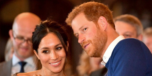 Britain's Prince Harry whispers to Meghan Markle as they watch a dance performance by Jukebox Collective in the banqueting hall during a visit to Cardiff Castle in Cardiff, Britain on Jan. 18, 2018.