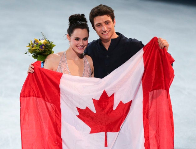 Virtue and Moir pose with the Canadian flag after winning silver at Sochi.