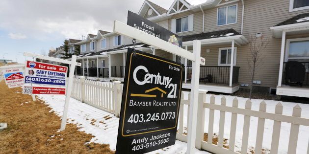 For sale signs line in Calgary, Alta., April 7, 2015. Calgary was among the cities that saw falling house prices in January, according to the Teranet-National Bank house price index.