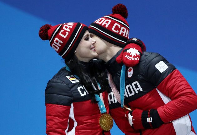 Tessa Virtue and Scott Moir celebrate during the medal ceremony for ice dance figure skating at the 2018 Olympics.