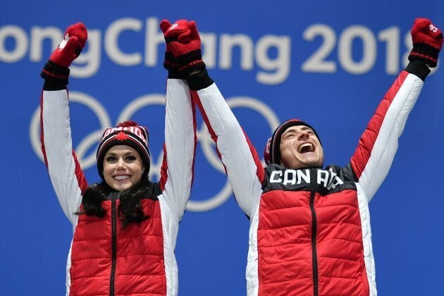 Canada's gold medallists Tessa Virtue and Scott Moir celebrate on the podium at the 2018 Olympics.