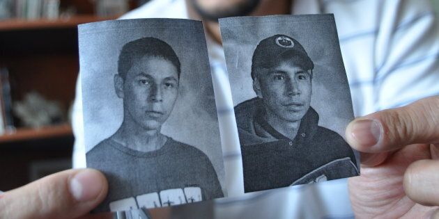 Teacher Greg Quachegan holds up pictures of two boys, Paul Panacheese on left and Curran Strang on the right. Both died while living far from home and attending Dennis Franklin Cromarty high school in Thunder Bay.