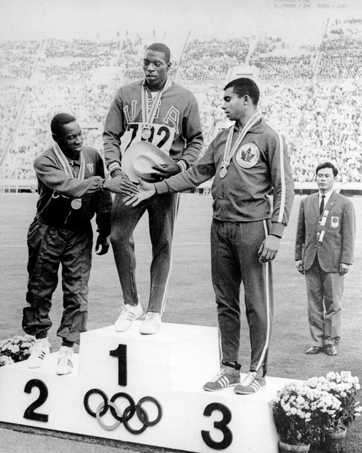 Harry Jerome (right) celebrates his bronze medal win in the 100m athletics event at the 1964 Tokyo Olympics.