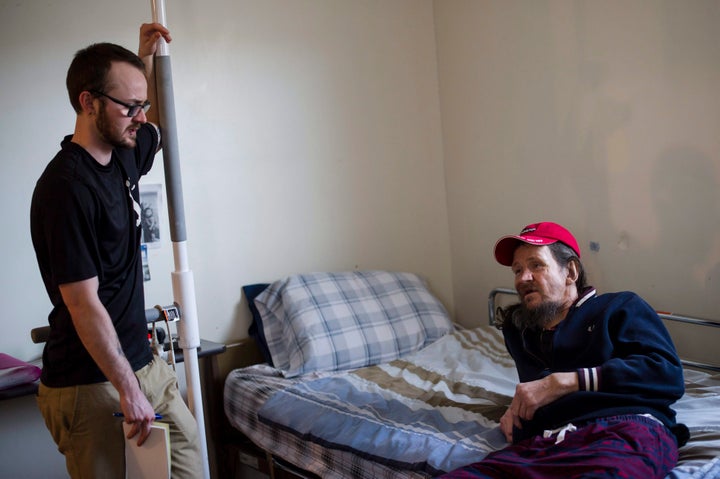 Case worker Jake McPhee speaks to Bruce Hughes in his room at the Art Manuel House in Toronto on Tuesday, Feb. 27, 2018.
