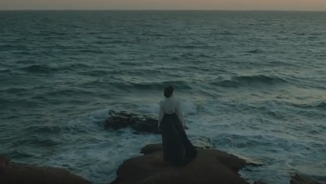 An actor portraying Lucy Maud Montgomery looks out over the ocean in a new Historica Canada Heritage Minute.