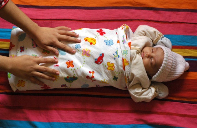 Woman adjusting baby's chador while he is asleep.