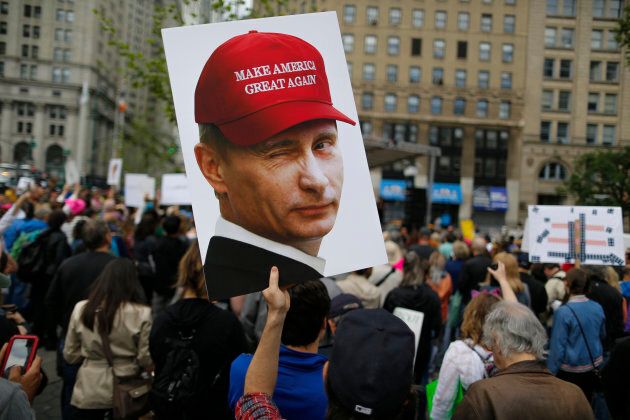 A demonstrator holds up a sign of Vladimir Putin during an anti-Trump