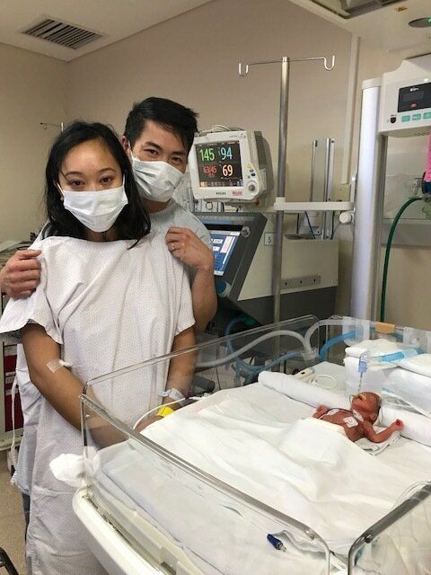 Eliza Hilario and Kar Leung stand over their baby, Madison, in a hospital in Manila. She was one day old at the time of the photo.
