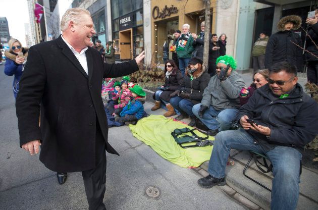Newly minted Ontario PC Leader Doug Ford in the St. Patricks Day Parade waves to folks sitting on the sidewalk on Bloor Street West.