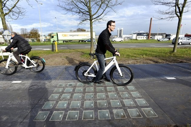 Cyclists use the SolaRoad, the first road in the world made of solar panels.