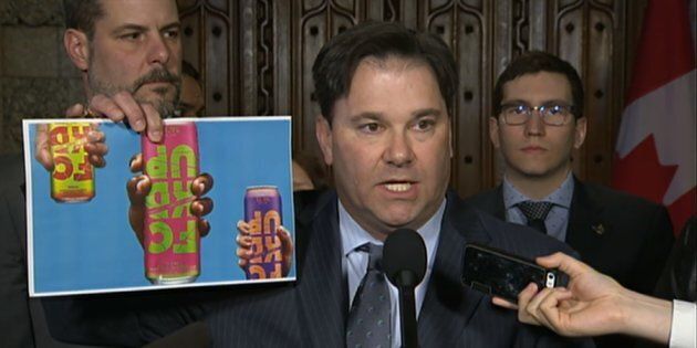 NDP MP Don Davies holds up an image of cans of an alcoholic drink called FCKD UP during a press conference in the House of Commons on March 19, 2018.