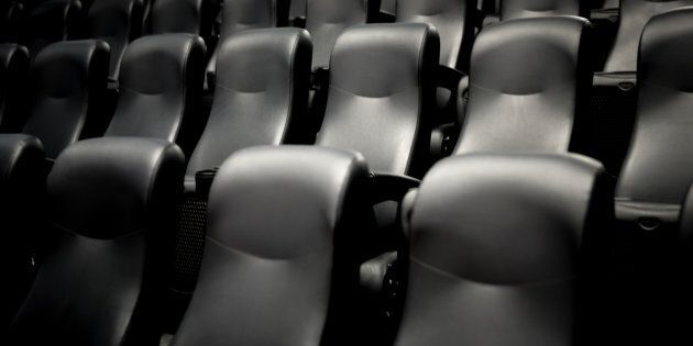 Empty movie theatre seats. A British movie chain is investigating the death of a moviegoer who reportedly became trapped under a footrest while trying to retrieve a dropped mobile phone.