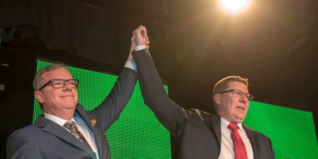 Former Saskatchewan premier Brad Wall, left, lifts the arm of Scott Moe, who won the party leadership to become the province's new leader during the Saskatchewan Party Leadership Convention in Saskatoon on Jan. 27, 2018.