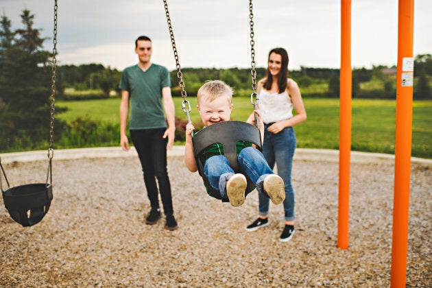 Caleb Herron laughing on a swing.