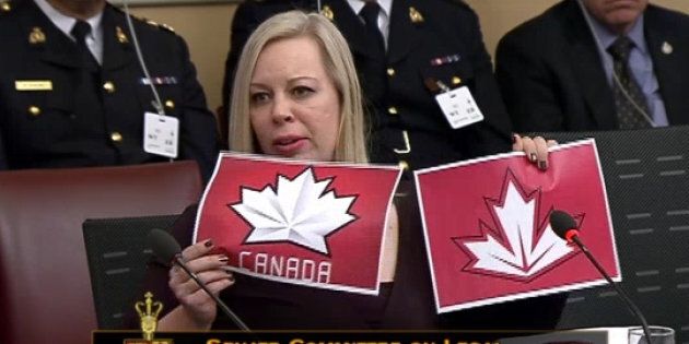 Sen. Denise Batters holds up two examples of logos used by Hockey Canada. The Conservative senator thinks young people will conflate the two, dulling warning messages on regulated cannabis products.