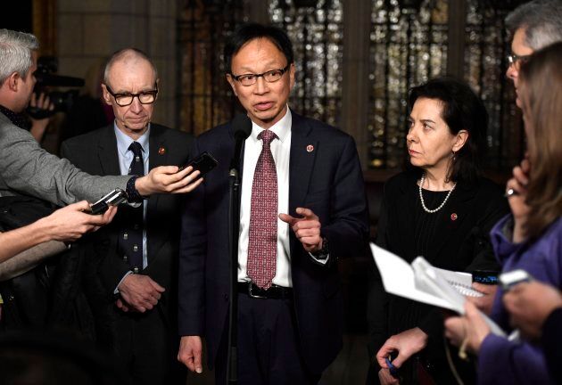 Sen. Yuen Pau Woo, facilitator of the Independent Senators Group, speaks to reporters along with Sen. Tony Dean, left, and Sen. Raymonde Saint-Germain, following a vote on Bill C-45, the Cannabis Act, on Parliament Hill in Ottawa on Thursday.