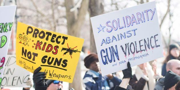 People hold up signs during a 'March for Our Lives' rally to show solidarity with the U.S. gun control movement in Montreal on Saturday.