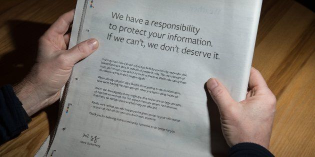 A man reads a full-page advertisment, taken out by Mark Zuckerberg, the chairman and chief executive officer of Facebook to apologize for the large-scale leak of personal data from the social network, on the backpage of a newspaper, in Ripon, England on March 25, 2018.