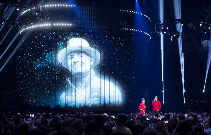 Kevin Drew, right, and Pearl Wenjack speak onstage as an image Gord Downie is projected during the Junos tribute.