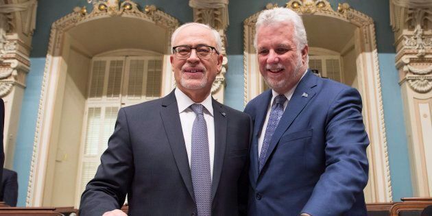 Quebec Finance Minister Carlos Leitao is joined by Premier Philippe Couillard, as he arrives to table his budget on March 27, 2018 at the National Assembly in Quebec City. The budget includes a measure to tax Netflix and other foreign online businesses.