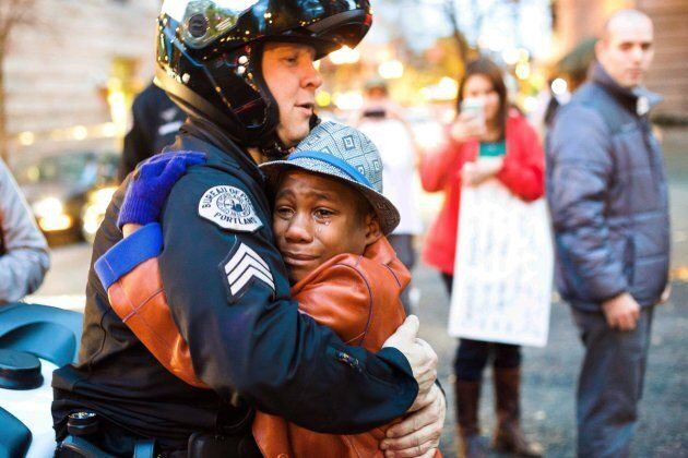 Portland police Sgt. Bret Barnum, left, and Devonte Hart, then 12, hug at a rally in Portland, Ore., where people had gathered in support of the protests in Ferguson, Mo. on Nov. 25, 2014.