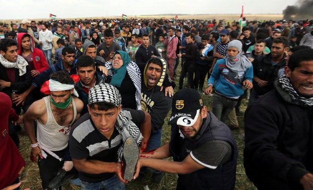 A wounded Palestinian woman is evacuated during clashes with Israeli troops during a protest along the Israel border with Gaza, demanding the right to return to their homeland, on the southern Gaza Strip on March 30, 2018.