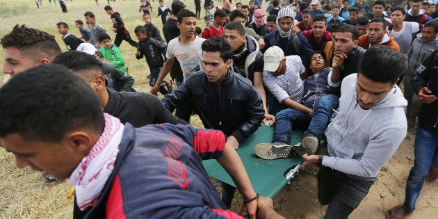 A wounded Palestinian is evacuated during clashes with Israeli troops, during a tent city protest along the Israel border with Gaza, demanding the right to return to their homeland, the southern Gaza Strip on March 30, 2018.