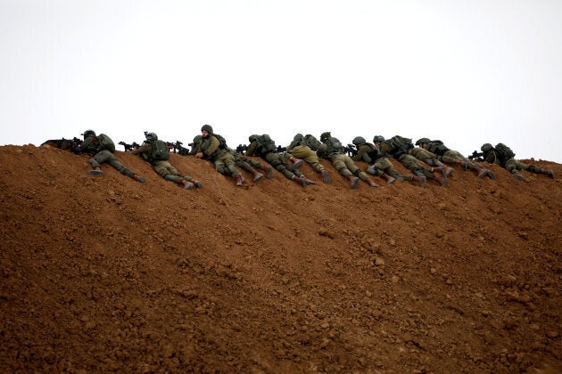 Israeli soldiers are seen next to the border fence on the Israeli side of the border with the northern Gaza Strip, Israel, on March 30, 2018.