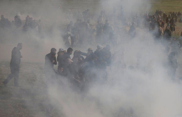 Palestinians run from tear gas fired by Israeli troops during clashes east of Gaza City on March 30, 2018.