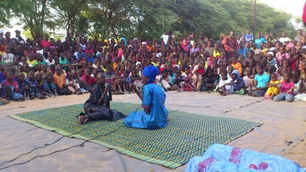 Children lead a street theatre performance about stopping tuberculosis.