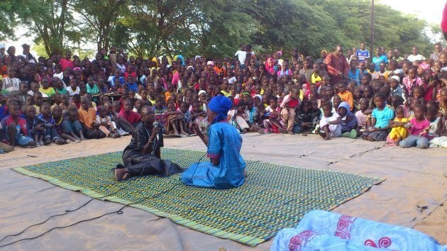 Children lead a street theatre performance about stopping tuberculosis.