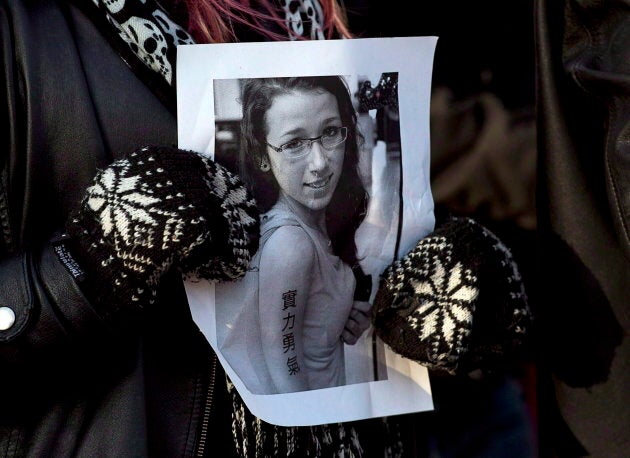 A woman holds a photo as several hundred people attend a community vigil to remember Rehtaeh Parsons at Victoria Park in Halifax on April 11, 2013.