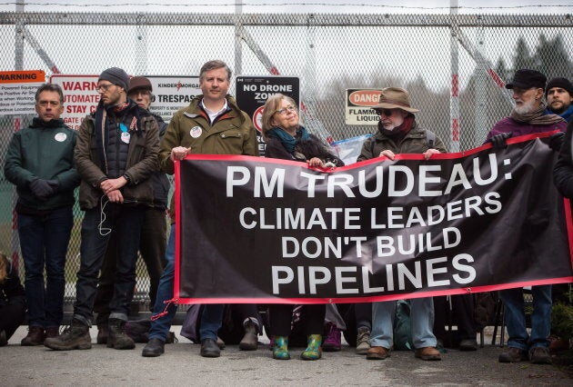 Green Party Leader Elizabeth May, centre, and NDP MP Kennedy Stewart, centre left, stand with protesters before they were arrested outside Kinder Morgan's facility in Burnaby, B.C., on March 23, 2018.