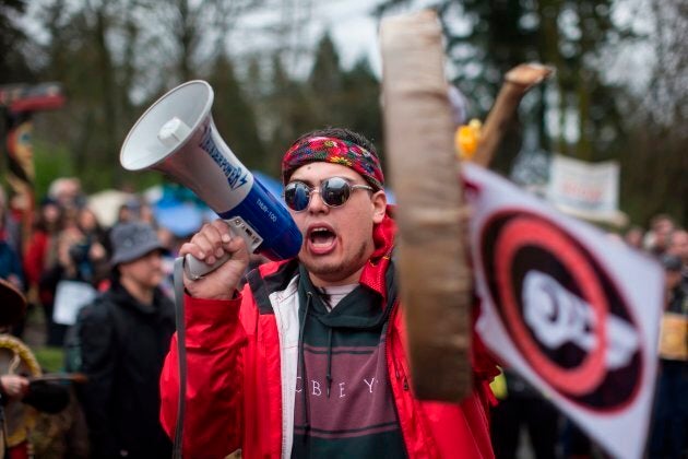 In this April 7, 2018 photo, Cedar George-Parker addresses the crowd as protesters opposed to the Kinder Morgan Trans Mountain pipeline extension defy a court order and block an entrance to the company's property, in Burnaby, B.C.