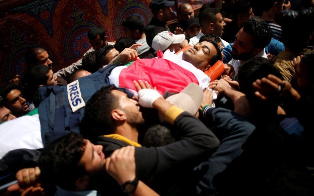 Colleagues of Palestinian journalist Yasser Murtaja, 31, who was killed by an Israeli sniper, carry his body during his funeral in Gaza, Gaza Strip, on April 7, 2018.