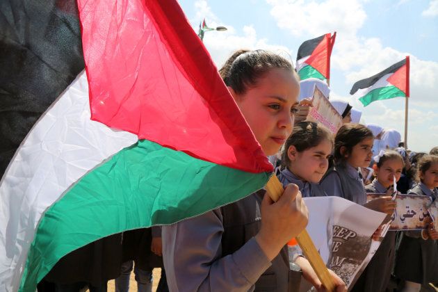 Palestinian students hold banners at the Israel-Gaza border in a tent city protest demanding the right to return to their homeland east of Gaza City, on April 9, 2018