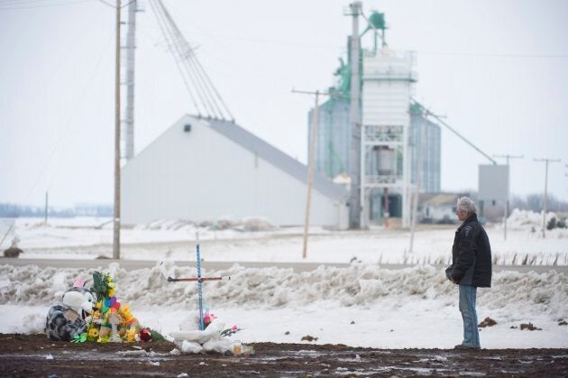 A man pays his respects at a make shift memorial at the intersection of a fatal bus crash near Tisdale, Sask. on April, 9, 2018.