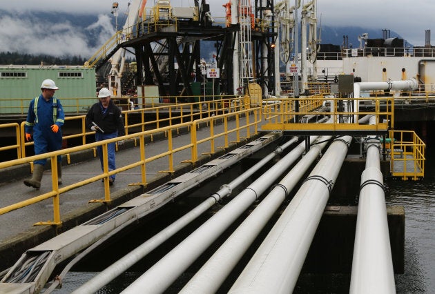 Workers walk to a jet fuel barge at Kinder Morgan's Westridge Terminal on Burrard Inlet in Burnaby, B.C., on Nov. 18, 2016.