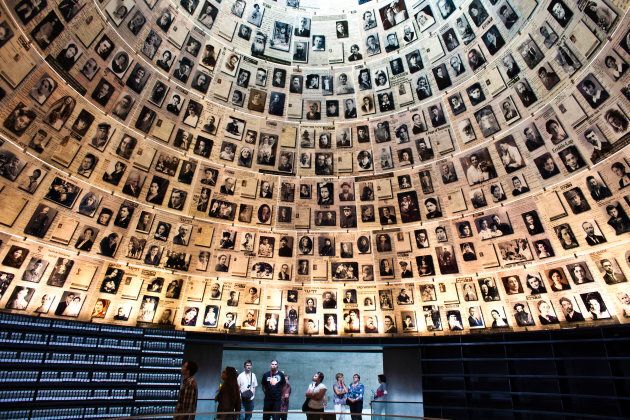 Visitors look at pictures of Jews killed in the Holocaust during a visit to the Hall of Names at Yad Vashem's Holocaust History Museum in Jerusalem on April 18, 2012.
