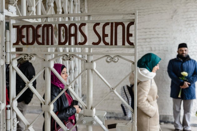 Syrian refugees go through the entrance to the Buchenwald concentration camp memorial to commemorate victims of the Holocaust on January 26, 2018 near Weimar, Germany.