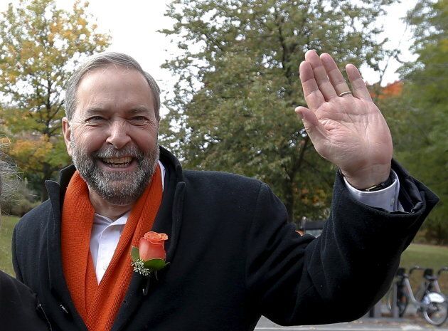Tom Mulcair waves after visiting a zone house in Montreal, Quebec on Oct. 19, 2015.