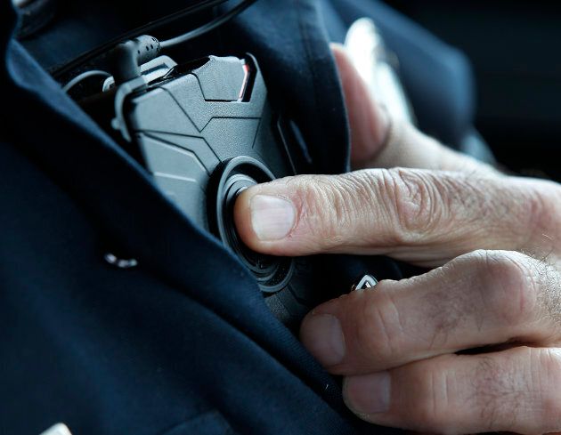 A police officer wears an Axon body camera.