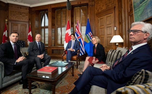 Prime Minister Justin Trudeau speaks before a meeting on the deadlock over Kinder Morgan's Trans Mountain pipeline expansion with B.C. Premier John Horgan, second from left, and Alberta Premier Rachel Notley, as Minister of Finance Bill Morneau, left, and Minister of Natural Resources Jim Carr looks on, in Trudeau's office on Parliament Hill on April 15, 2018.