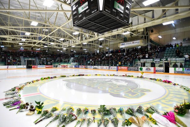 Flowers lie on the ice as people gather for a vigil on April 8 at the Elgar Petersen Arena, in Humboldt, Saskatchewan, home of the Humboldt Broncos, to honour the victims of a fatal bus accident
