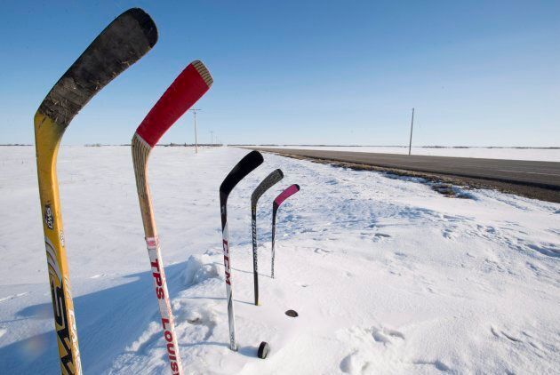 Hockey sticks to remember members of the Humboldt are seen standing in a snowbank along a stretch of highway 6 in Saskatchewan on April, 13, 2018.