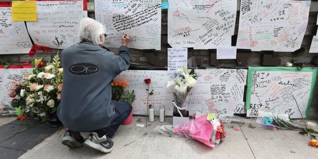 Jack Young leaves a note on a makeshift memorial for victims in the van attack in Toronto on April 24, 2018.